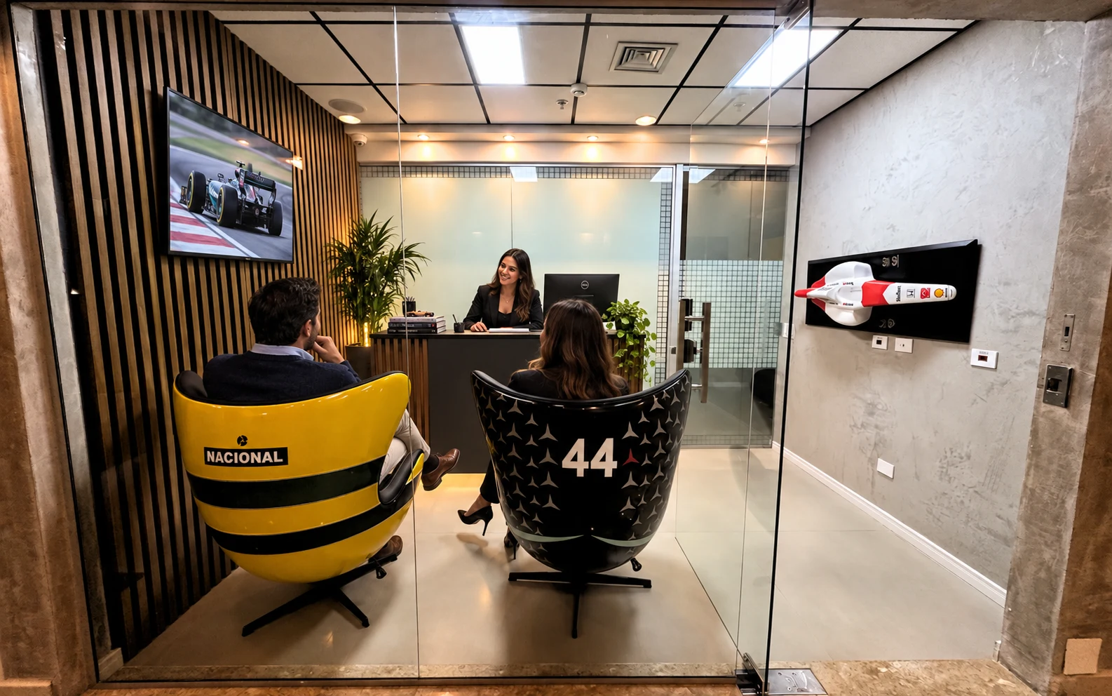 Visualização da recepção Veloce com visitantes nas poltronas automotivas, recepcionista no balcão e TV na parede esquerda.